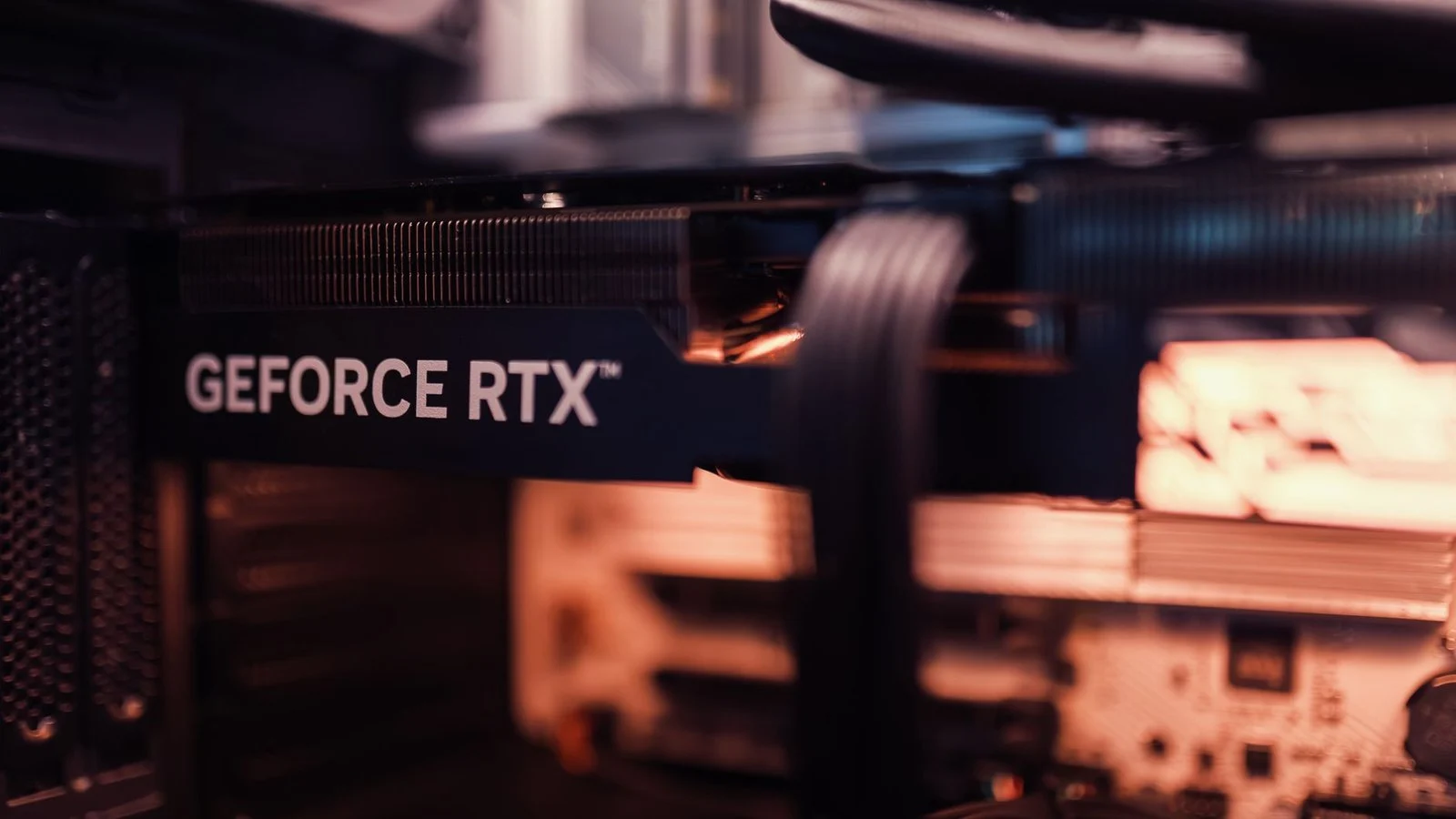 A GeForce RTX graphics card installed in a PC with its power cable connected