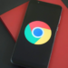 Smartphone displaying the Google Chrome logo, resting on a red box