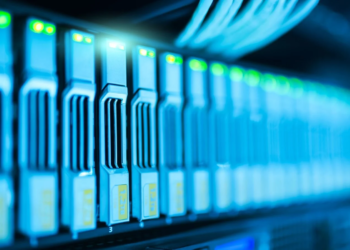 Row of blue-lit server storage drives with green status LEDs in a data center rack