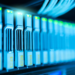 Row of blue-lit server storage drives with green status LEDs in a data center rack