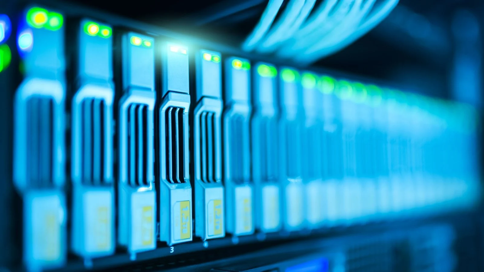Row of blue-lit server storage drives with green status LEDs in a data center rack
