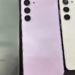 Three Samsung phone backs side by side, green with many cameras, purple and cream with three cameras