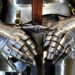 Close-up of steel plate armor gauntlets gripping a sword hilt against the chest