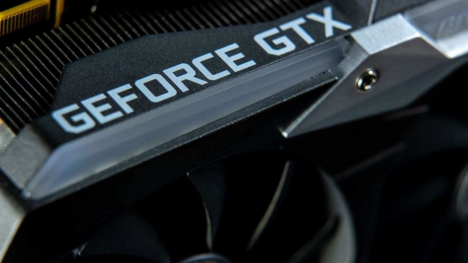 Close-up of a black GeForce GTX graphics card with cooling fan and heatsink fins
