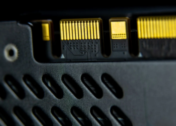 Extreme close-up of gold connector pins on a black perforated heat spreader