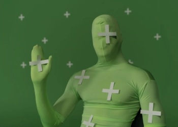 Person in green motion-capture suit with white tracking markers against a green screen backdrop