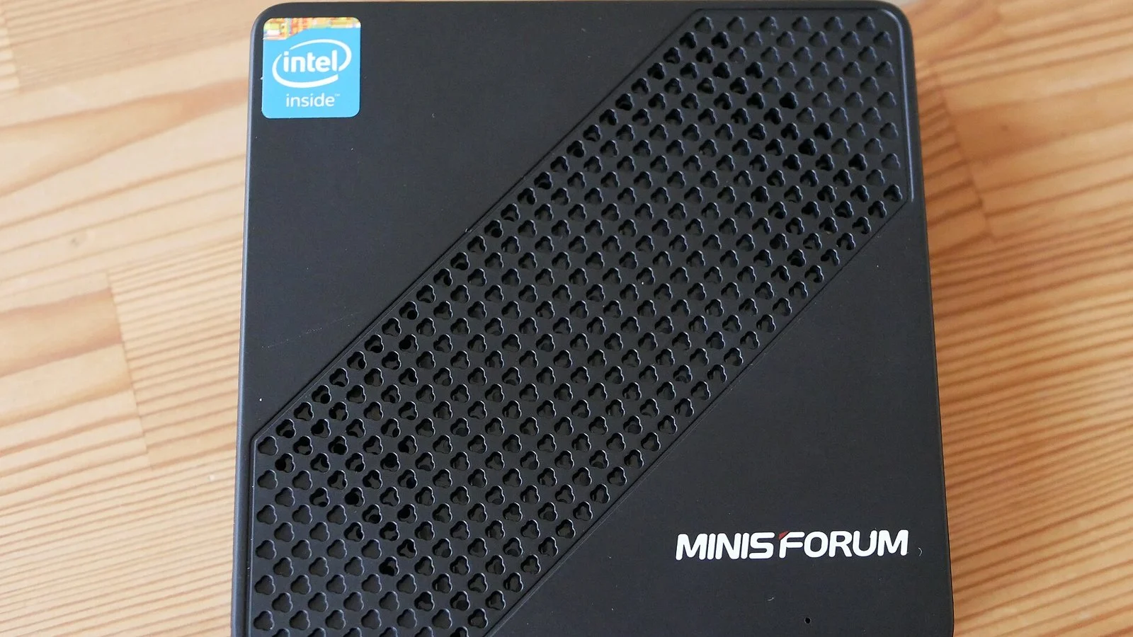 Black Minisforum mini PC with mesh vent pattern and Intel Inside sticker, viewed from above