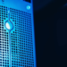 Close-up of a blue-lit perforated server panel with a teardrop-shaped LED indicator