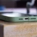 close-up of a phone's bottom edge in a green case showing USB-C port on a wooden table