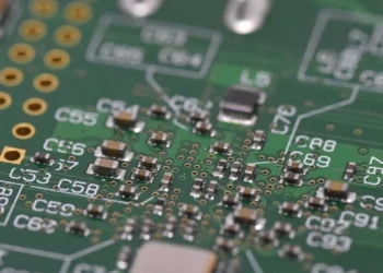 Close-up of a green circuit board with surface-mount components and labeled capacitor pads