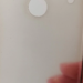 Blurry close-up of a translucent phone case with a white circular ring, held by a hand