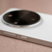 Close-up of a white smartphone's round camera bump with black glass lens module