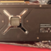 Backplate of an AMD Radeon RX 480XT Black Edition graphics card lying on foil packaging