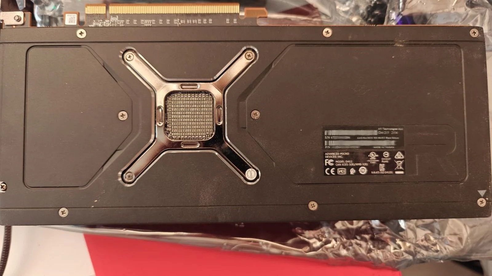 Rear backplate of an AMD Radeon RX x60XT Black Edition graphics card with X-shaped bracket