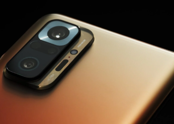 Close-up of a gold smartphone's rear camera module with three round lenses and PREMIUM/ULTRA text