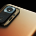 Close-up of a gold smartphone's rear camera module with three round lenses and PREMIUM/ULTRA text