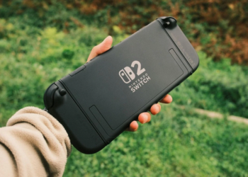 Hand holding the black rear panel of a Nintendo Switch 2 console outdoors