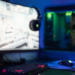 Gaming PC desk with curved monitor showing a game, headphones hooked on it, RGB tower and mouse