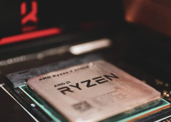 AMD Ryzen processor seated in its motherboard socket, close-up with red RGB lighting in background