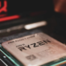 AMD Ryzen processor seated in its motherboard socket, close-up with red RGB lighting in background