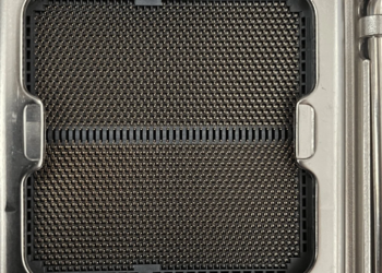 Close-up of an empty AM5 motherboard CPU socket with metal contact pins and retention arms
