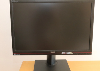 ASUS ProArt monitor with black screen off, on a stand, against a white wall