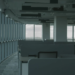 Empty modern office with rows of vacant cubicle desks beside floor-to-ceiling windows