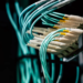 Close-up of teal fiber optic cables plugged into a Cisco Nexus network switch