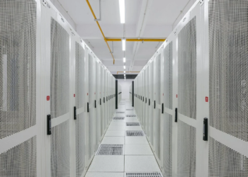 Server room aisle with rows of perforated white equipment cabinets and raised floor vents