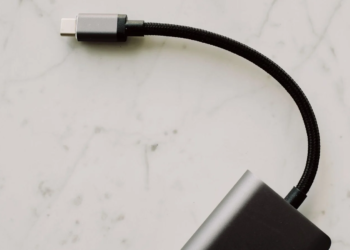 Braided USB-C cable plugged into a small black device on a marble surface