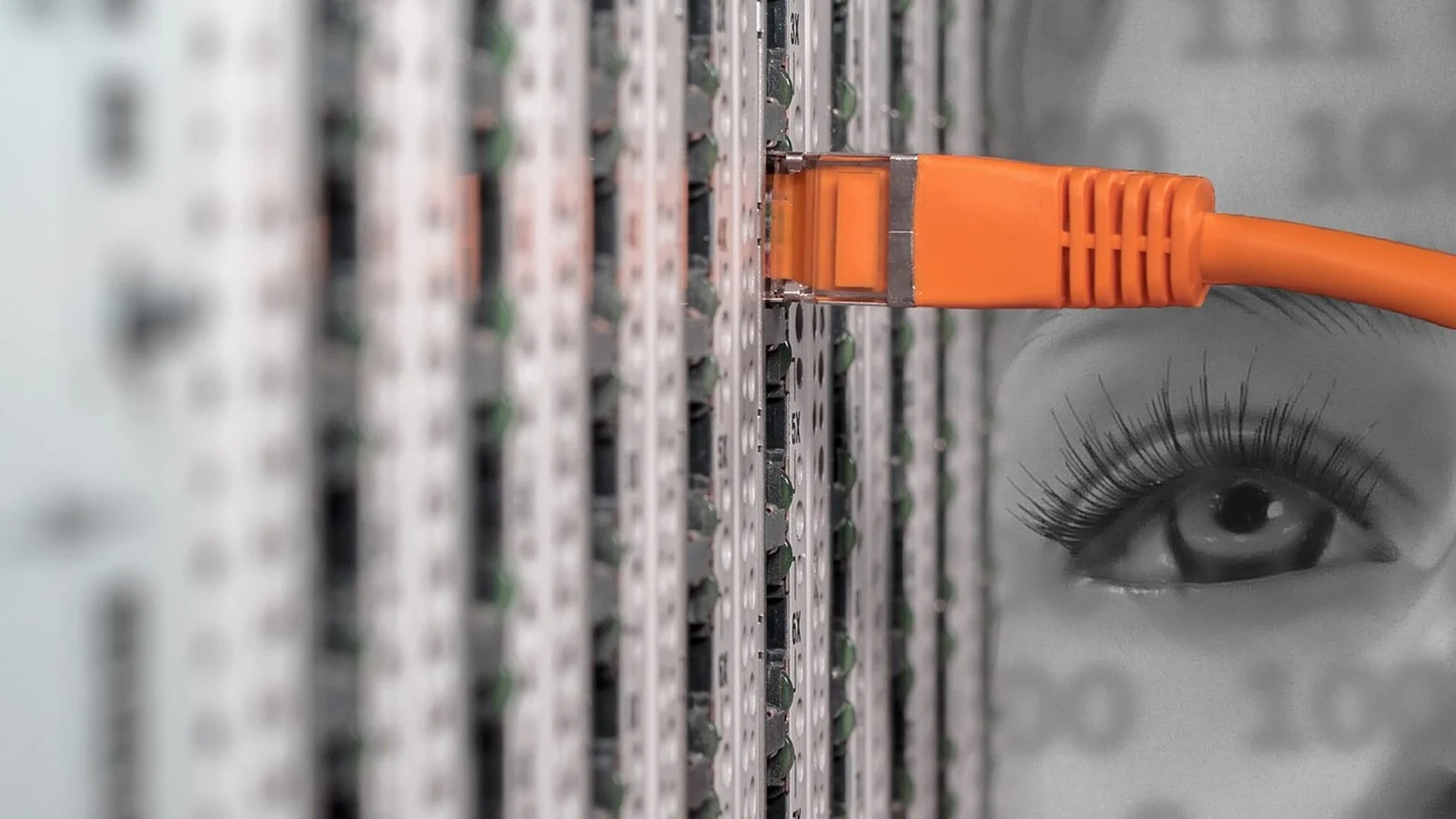 Orange network cable plugged into a server patch panel, with a ghostly eye superimposed over binary code