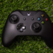 Black Xbox wireless controller resting on artificial turf grass