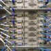 Rear view of a server rack with dozens of blue and white labeled network cables