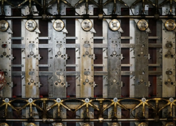 Close-up of a mechanical device's internal gears, wiring, and rotor-like metal plates