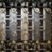 Close-up of a mechanical device's internal gears, wiring, and rotor-like metal plates