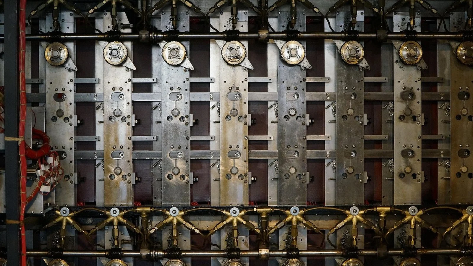 Close-up of a mechanical device's internal gears, wiring, and rotor-like metal plates