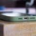 Close-up of a green-cased smartphone's USB-C port edge resting on a wooden table