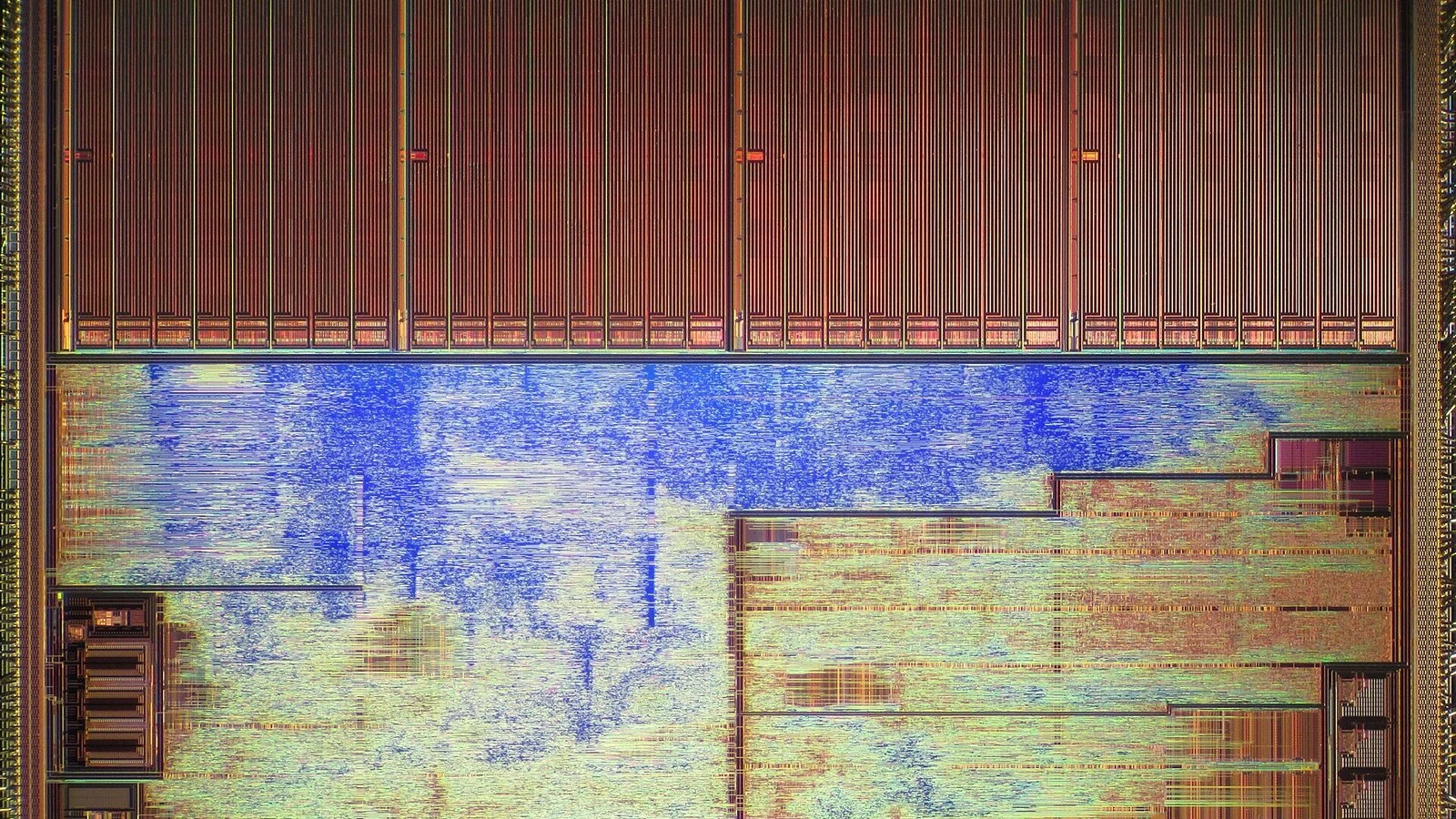 Extreme macro shot of bare silicon die circuitry with copper-toned traces and a blue-tinted region
