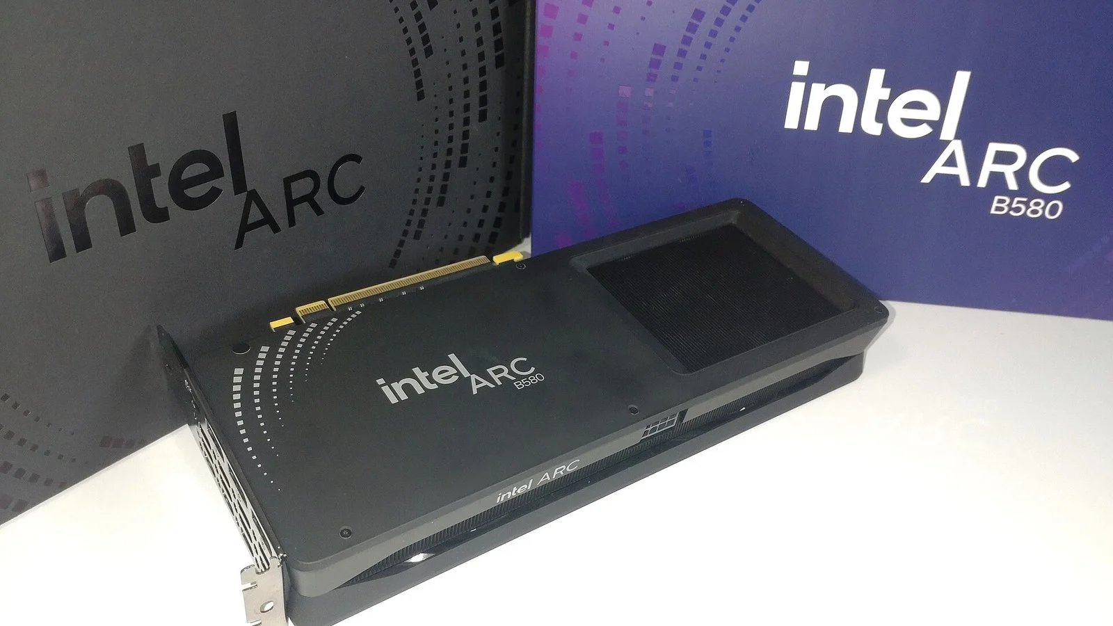 Intel Arc B580 graphics card resting against its retail packaging boxes