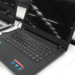 Black Lenovo IdeaPad 110 laptop displayed open on a store shelf beside other laptops