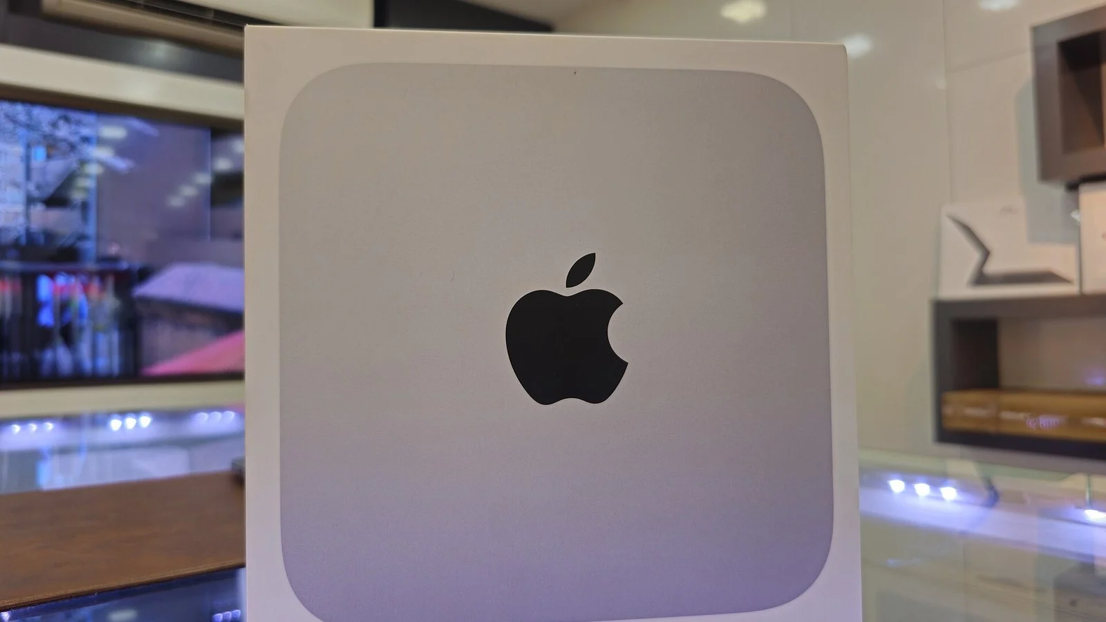 Sealed white Apple product box with black Apple logo on a store shelf