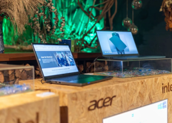 Acer laptops on display at an Intel-branded event booth with green plant decor