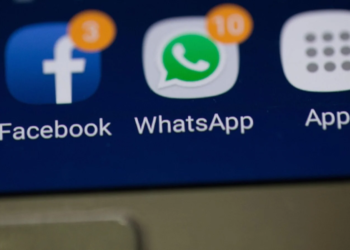Close-up of a phone screen showing Facebook and WhatsApp app icons with notification badges