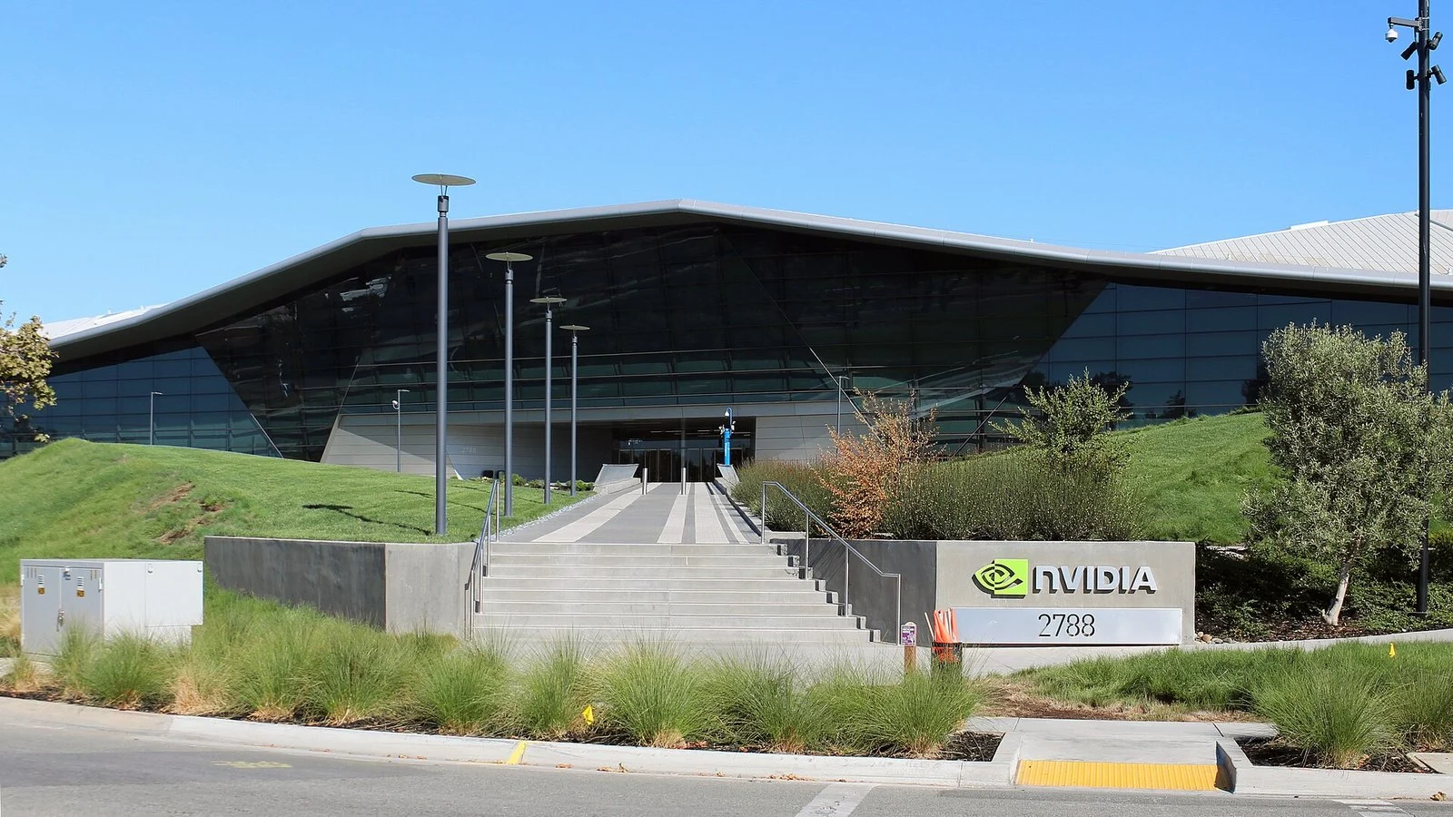 Nvidia's headquarters entrance with a triangular glass roof and Nvidia logo sign