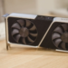 Silver and black GeForce RTX graphics card with two fans on a wooden desk