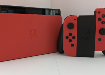 Red Nintendo Switch console back panel beside a red and black Joy-Con controller grip