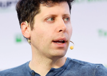 Man speaking into a headset microphone at a conference panel