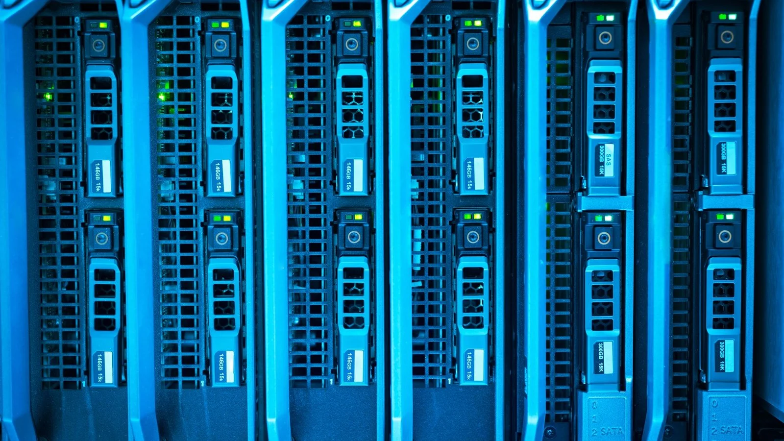 Rows of blue-lit server hard drive caddies in a data center rack