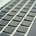 Close-up of a dark laptop keyboard with backlit-style keycaps, shallow depth of field