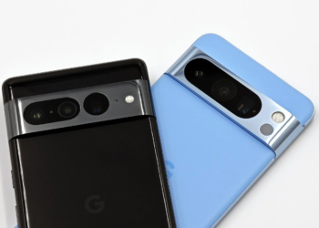 Two Pixel smartphones, black and light blue, lying face-up showing camera bars, no charging accessory visible